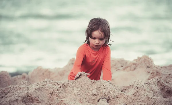 Wakacje z dziećmi. Dzieciak bawi się na plaży. Dziecko produkujące zamek z piasku na morzu. — Zdjęcie stockowe