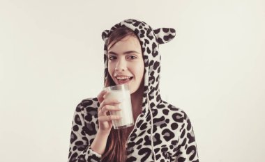 Belki sıcak bir banyo ve bir bardak süt. Benekli pijamagenç güzel kadın süt bardak tutan. Bir bardak süt içen sevimli bir kız. Uyumadan önce bir bardak ılık süt almak