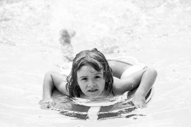 Çocuklar yazı. Havuz tatili. Aquapark 'ta gülümseyen çocuk. Çocuk suda yüzüyor. Havuzda hareketlilik. Yaz tatili.