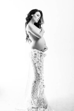 Hamilelik. Doğum hazırlığı. Kadın sağlığı. Koca göbekli kız. Müstakbel annenin içeride bebeği olacak. Yaşam beklentisi. Sevgi. Bahar çiçeği etekli güzel hamile kadın. Bebek bekliyorum.