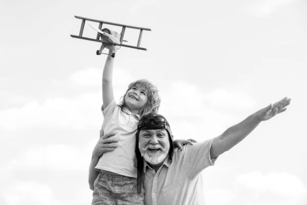 小男孩和爷爷在夏天的天空背景下玩玩具飞机。和爷爷的周末. — 图库照片