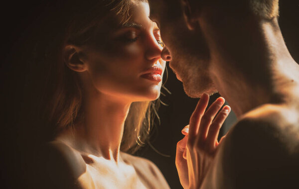 Couple in love going for the kiss. Close up face of a beautiful young couple in love embracing, romance and and affection.