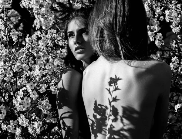 Lente natuurlijke schoonheid. Bloom lesbisch stel op bloesem kersenpark. mooi sexy meisje vrienden met bloemen. — Stockfoto