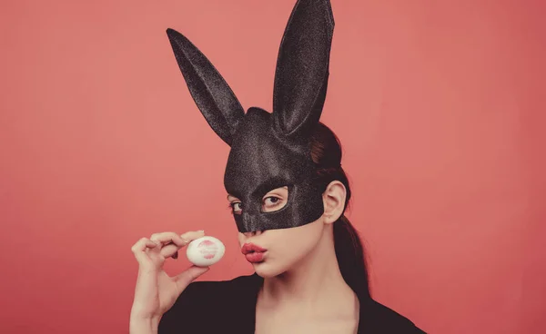 Pasen vrouw. Vrouw konijn, easter bunny meisje. Rode lip afdruk op easter egg op rode achtergrond. Vrouwelijke mond kus. Afdrukken van rode lippen op witte ei. — Stockfoto