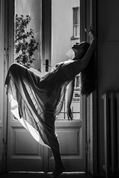 Femme rencontre matin près du balcon. Détends-toi. Jeune femme debout près de la fenêtre. Nuisette érotique. Passion et tentation. Elle danse joyeusement. — Photo