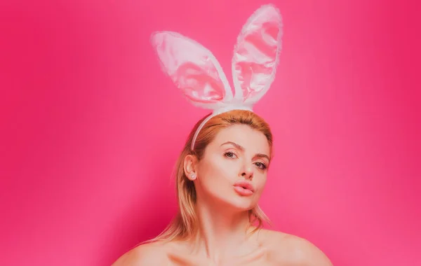 Preciosa mujer joven sensual hermosa posando en orejas de conejo rosa. Estudio de la chica de Pascua aislado en rosa. —  Fotos de Stock