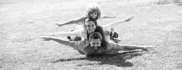 かわいい家族の肖像画。夏の公園でアウトドアを楽しんでいる母親の父と子供の息子。テキスト用のコピースペースを持つバナーパノラマ. — ストック写真