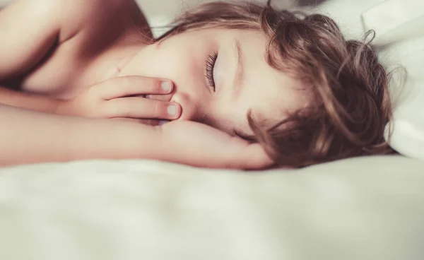 Malé děti spí s otevřenou pusou a chrápou. Dítě v ložnici spát na posteli s bílým prostěradlem a polštářem. — Stock fotografie