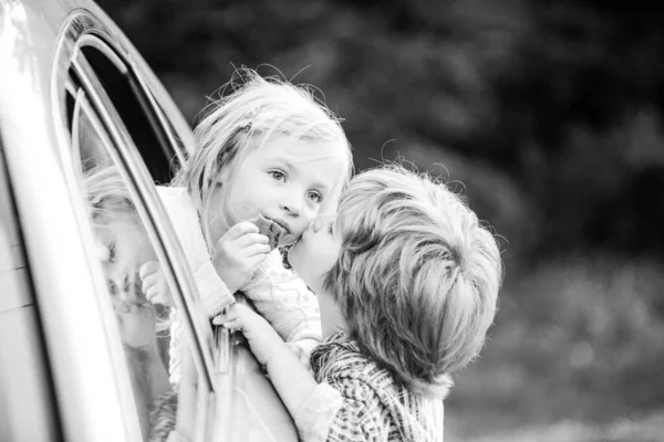 Two kids saying goodbye before car travel. Little boy gives kiss for cute girl. Good bye before car travel. — Stock Photo, Image