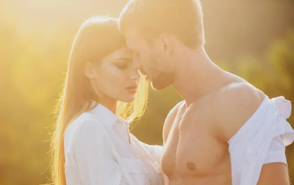 Jovens amantes abraçando e abraçando ao pôr do sol. Casal no amor ternura e carinho. — Fotografia de Stock