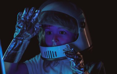 Çocuk uzayı keşfediyor. Uzay kıyafetleri içindeki sevimli çocukların portresi. Kozmonotik gün konsepti. Heyecanlı çocukların yüzlerini neon rengine yakın tut.