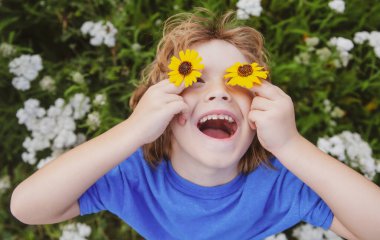 Bahar parkındaki yeşil çimlerde mutlu, heyecanlı çocuk. Sağlıklı yaşam tarzları konsepti.