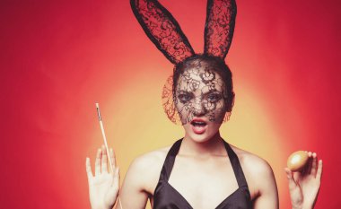 Geleneklere saygı göster. Mutlu Paskalyalar. Tavşan kız fırçayı tutup yumurta kırmızısına boyuyor. Altın yumurtayı süsleyen sevimli tavşan kadın. Paskalyayı kutluyoruz. Geleneksel kutlama. Paskalya geliyor.