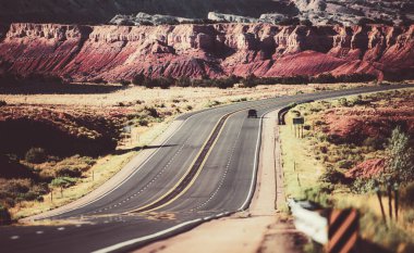 Taşlı manzara, güneşli gökyüzü bulutlu ve güzel asfalt yol.