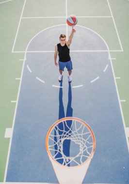 Basketbol oynayan bir adamın bakış açısı, basketbol oynayan bir adamın potasının üstü. El dönen basket topu. Basket topunu parmağında dengelemek.