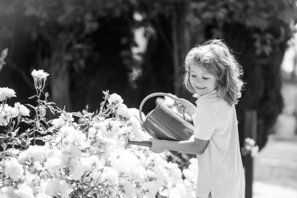 Amerikanische Kindheit. Kind gießt Blumen im Garten. Gartenarbeit zu Hause — Stockfoto