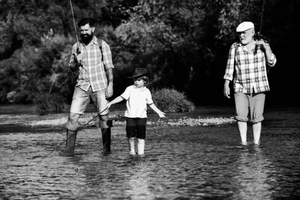 Generación familiar y concepto de personas. Niño con padre y abuelo volar pesca al aire libre sobre el fondo del río . — Foto de Stock