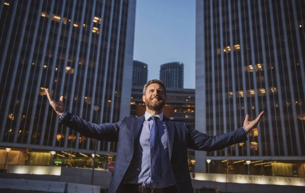 Homem de negócios levantar-se e noite fundo da cidade. Empresário levantando armas perto do prédio de escritórios da cidade. Feliz, sucesso e triunfo empresarial, celebrando a vitória. — Fotografia de Stock