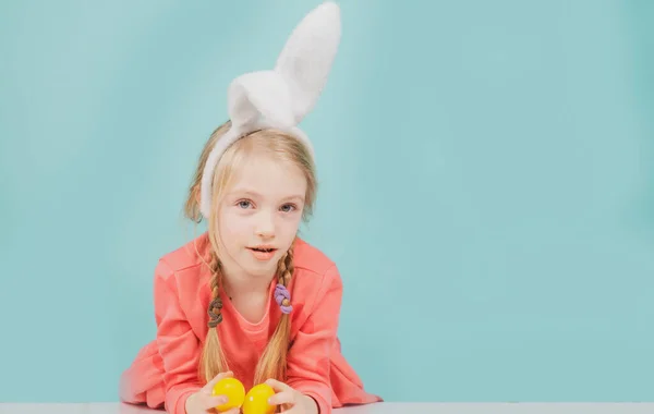 Девочка с пасхальными яйцами, весенняя праздничная концепция. Удивленный ребенок в кроличьих ушах на отдыхе. — стоковое фото
