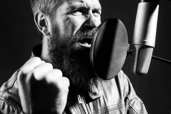 Sänger mit Kopfhörer performt einen Song mit Mikrofon während der Aufnahme in einem Musikstudio. — Stockfoto