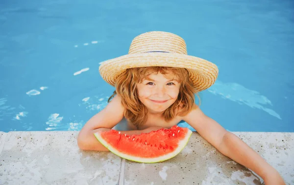 Lindo niño en la piscina comiendo sandía. Disfruta comiendo frutas tropicales. Concepto de niños de verano. Feliz infancia.. — Foto de Stock
