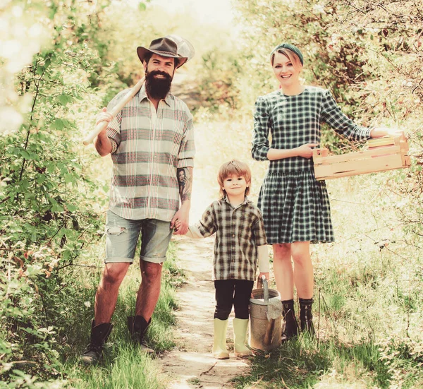 Famiglia che lavora insieme in fattoria. Famiglia nella fattoria sullo sfondo della campagna. Diventare agricoltori biologici. — Foto Stock