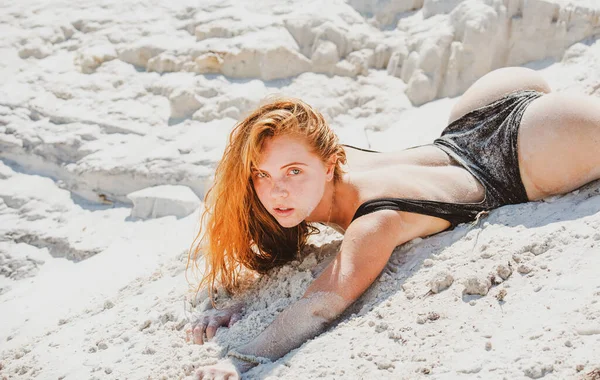 Zomervrouw lichaam. Sensueel meisje liggend in het zand op het strand. Vakantie in het Paradijs. Zandmeisje op zandstrand. — Stockfoto