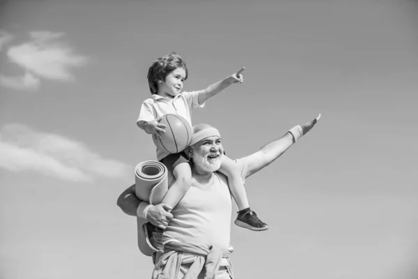 Starszy mężczyzna i dziecko w rodzinnym klubie zdrowia. Uprawianie sportu jest bezpłatne. Dziadek i wnuk plamiący. Dziadek i dziecko uprawiają sport na świeżym powietrzu. — Zdjęcie stockowe