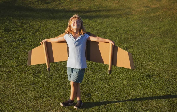 Bambino ragazzo che gioca e sogna di vacanze estive e viaggi. Immaginazione dei bambini e concetto di libertà. Bambino sogno di volare, viaggiare in aereo, fantasie. — Foto Stock