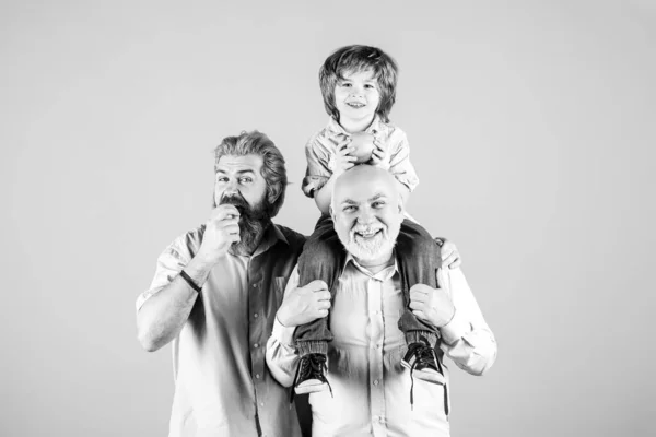 祖父と孫はリンゴを抱きかかえて食べています。異なる年齢の男性,黄色に隔離されました. — ストック写真