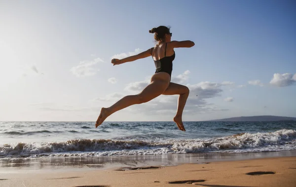 シルエットを動かす女。健康フィットネス女の子ジョギングでビーチ. — ストック写真