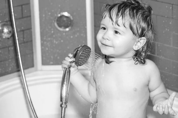 Babydouchen. Portret van een kind badend in een bad met schuim. Grappige kinderen staan voor close-up. Kind baden onder een douche. — Stockfoto