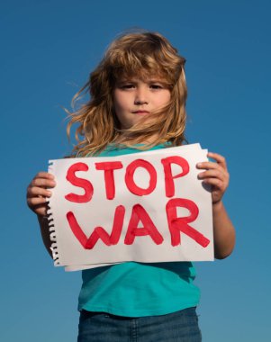 Çocuk savaşı protesto ediyor. Çocuk savaşı durdurun diyor, yazıyla bayrağı kaldırıyor savaşı durdurun. Rusya çatışması ve askeri protesto afişi olan çocuklar..