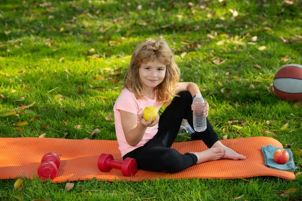 Hälsosam mat och hälsosam livsstil hos barn, pojke efter sport sitter på idrottsmatta och äta äpplen. Begreppet barn idrott. — Stockfoto