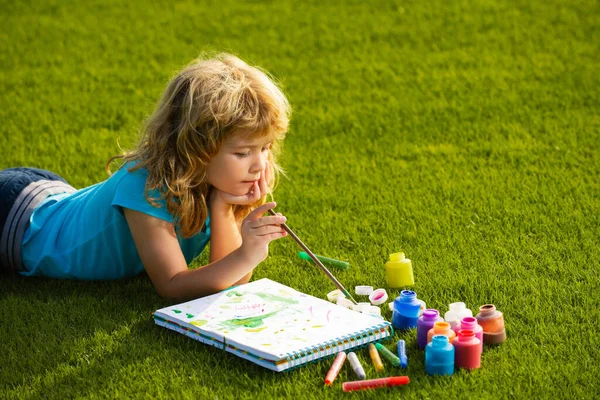 Künstlerkinder. Schulkinder zeichnen im Sommerpark, malen Kunst. Kleiner Maler zeichnet Bilder im Freien. — Stockfoto