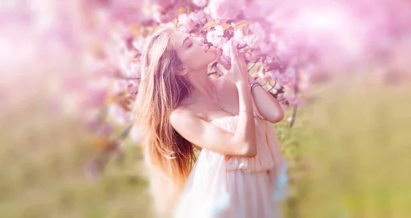 Hermosa mujer joven primavera al aire libre disfrutando de la primavera. Hermosa joven cerca del floreciente árbol de primavera. Juventud, amor, moda, concepto romántico y de estilo de vida. — Foto de Stock