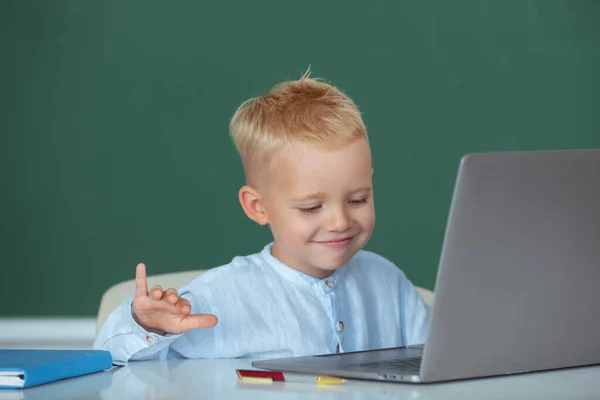 Šťastné dítě pomocí gadgets ke studiu. Počítačové vzdělávání pro děti. Vtipné blondýny žák na tabuli. — Stock fotografie