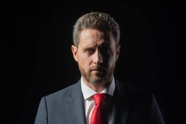 Siyah arka planda orta yaşlı bir iş adamının portresi. Ciddi iş adamı..