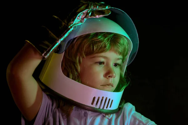 子供の男の子は宇宙ヘルメットの宇宙飛行士であることを自分自身に想像する。黒、冒険の想像力に隔離された子供の肖像画を閉じます. — ストック写真