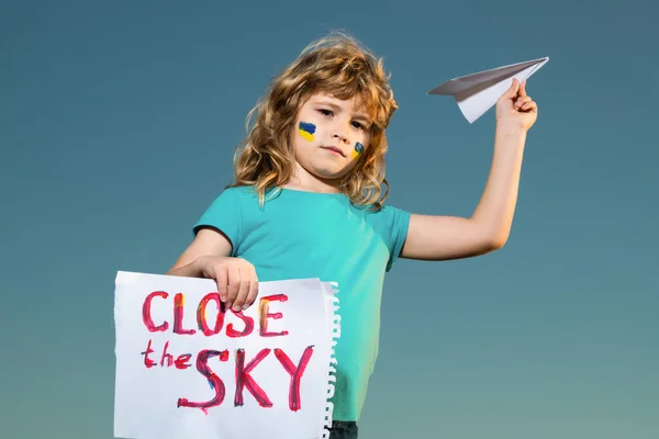 Sluit de lucht boven Oekraïne banner. Geen vliegzone boven Oekraïne. Oekraïense vlag op de wang van kinderen. Militaire Oekraïense vliegtuigen. — Stockfoto