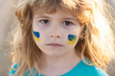 Çocukların yanağında Ukrayna bayrağı. Küçük Ukraynalı vatansever.