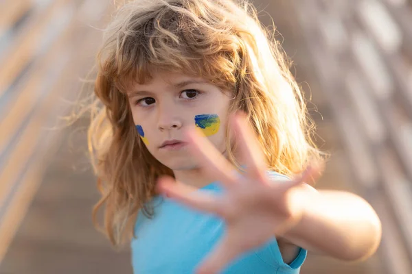 子供の頬にウクライナ国旗のサイン。戦争も戦争もロシアの侵略も. — ストック写真