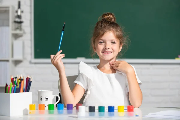 Aranyos kislány gyermek festmény festékek szín és ecset. A gyerekek kreatívak. Rajzóra az iskolában. — Stock Fotó