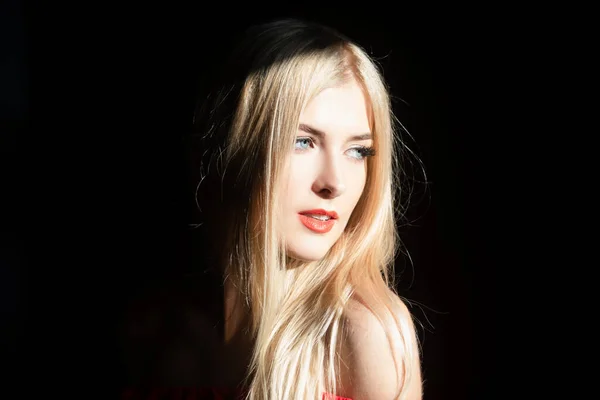 Mujer joven posando en el estudio sobre fondo negro. Luz y sombra. Retrato de moda de mujer hermosa con luz oscura en la cara. —  Fotos de Stock