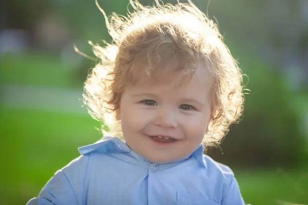 Baby kind genieten van de zomer op de natuur in het park buiten. Baby gezicht close-up. Grappig klein kind close-up portret. Blond kind, lachende emotie gezicht. — Stockfoto