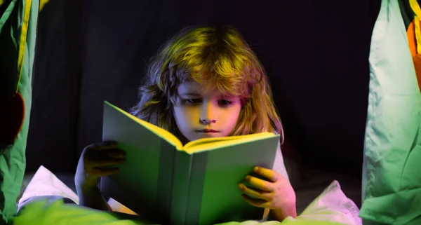 Niños, hora de dormir. Niño leer libro en la cama. —  Fotos de Stock