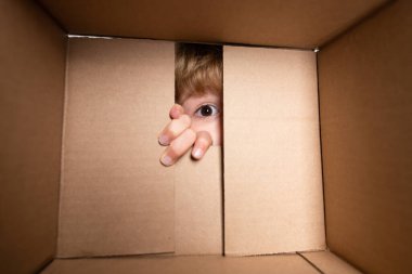 Hediye kutusunu karıştıran, komik bir ifadeyle hediye paketini açan sabırsız çocuk boks sürprizi. Gözlerini kapat ve bak. Paketler ve teslimat.