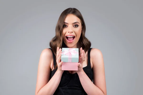 Возбужденная женщина с подарочной коробкой с удивленным выражением лица, изолированным фоном. Рождество, валентинки или подарки на день рождения. Портрет красавицы-модели. — стоковое фото