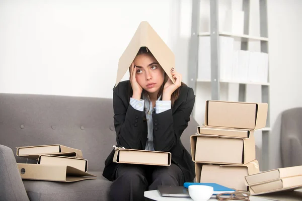 Chica secretaria triste con la carpeta en la cabeza, estresado mujer de negocios sobrecargado de trabajo demasiado trabajo, problema de oficina. Mujer joven cansada estresada empleada. —  Fotos de Stock