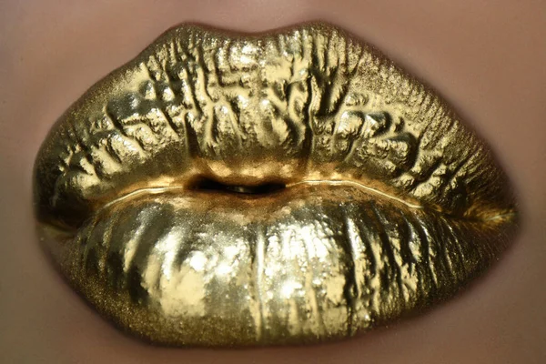 Gyllene kyss. Gyllene läppstift på läpparna, kvinnlig guldmun. Avtrycksläppar. — Stockfoto